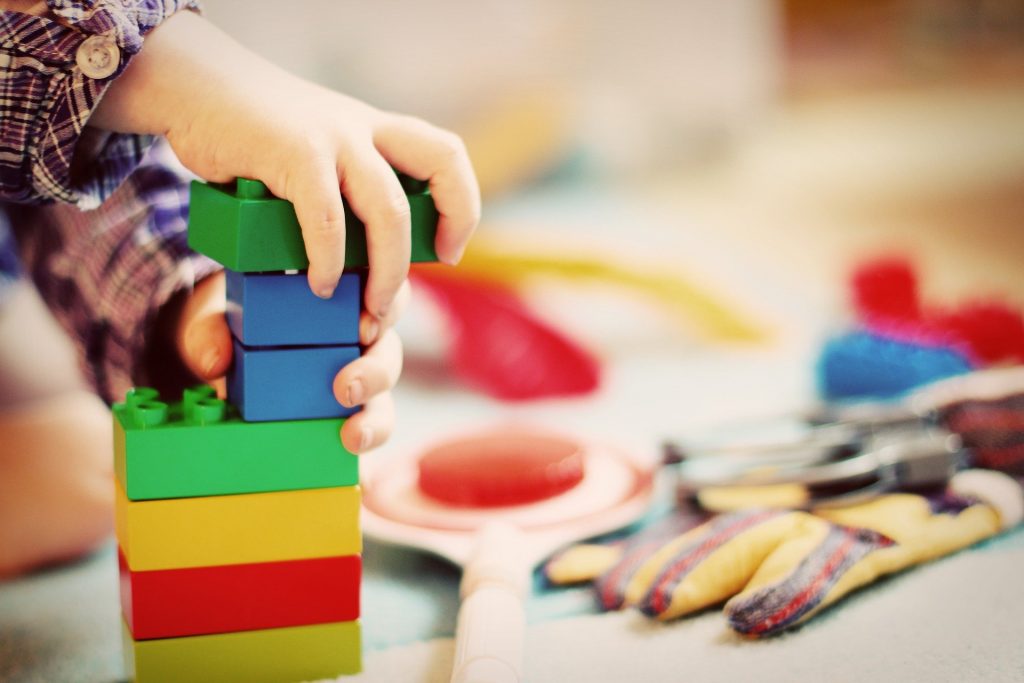 Child playing with colourful building blocks