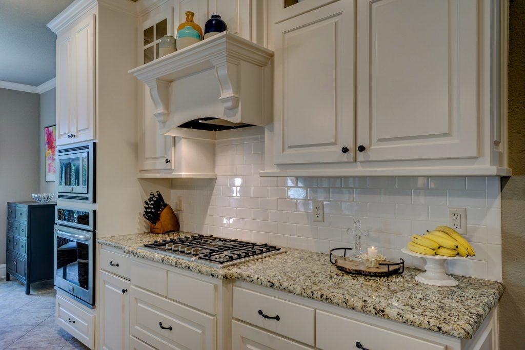 Kitchen with marble countertops and white cabinets