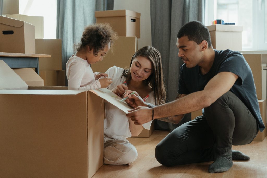 Family with young daughter hiding in box