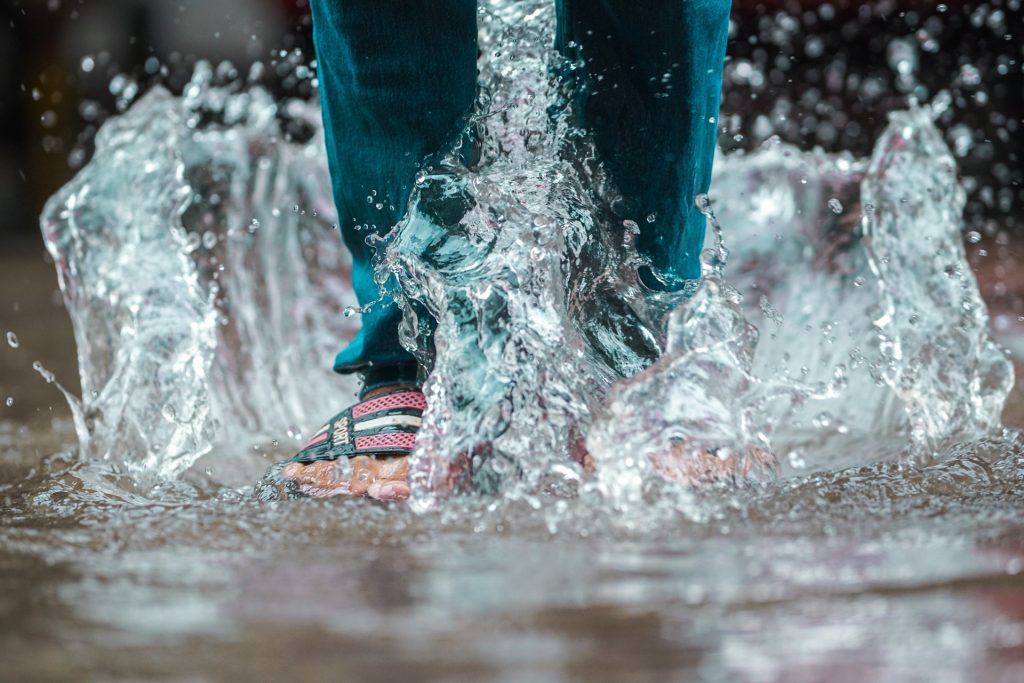 Feet splashing in puddle