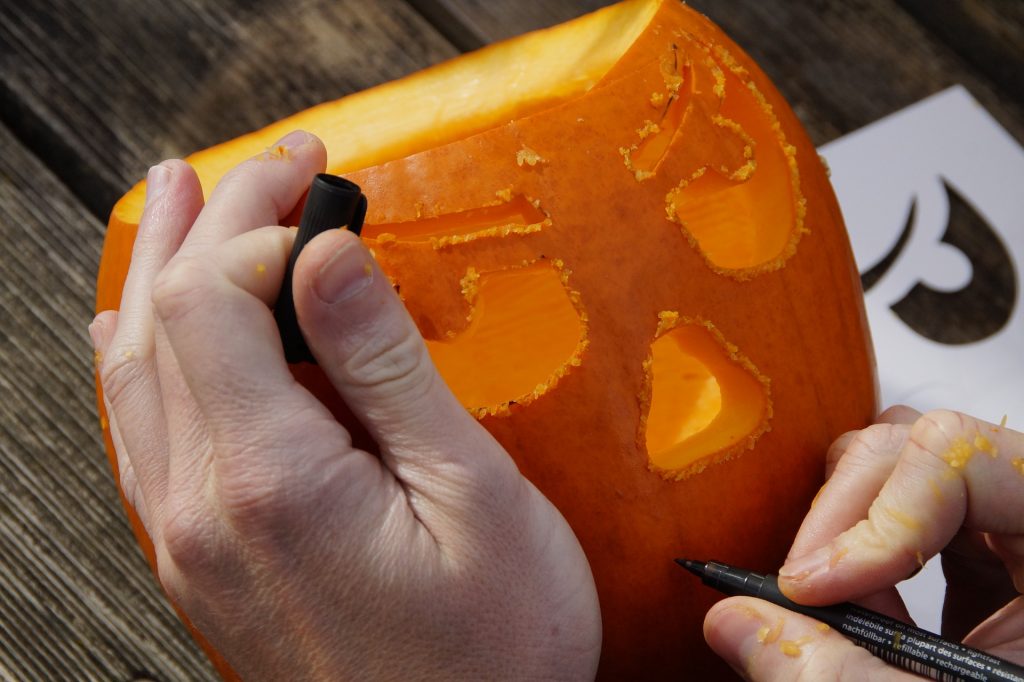 Hands carving a pumpkin