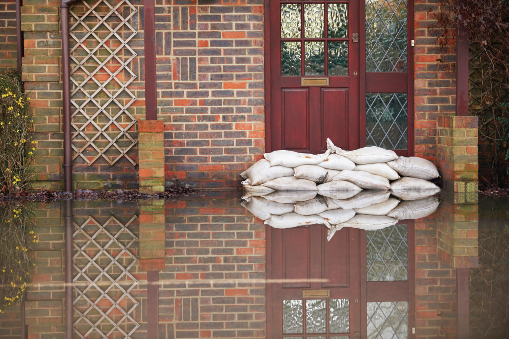 House with flood water coming up to door with sandbags