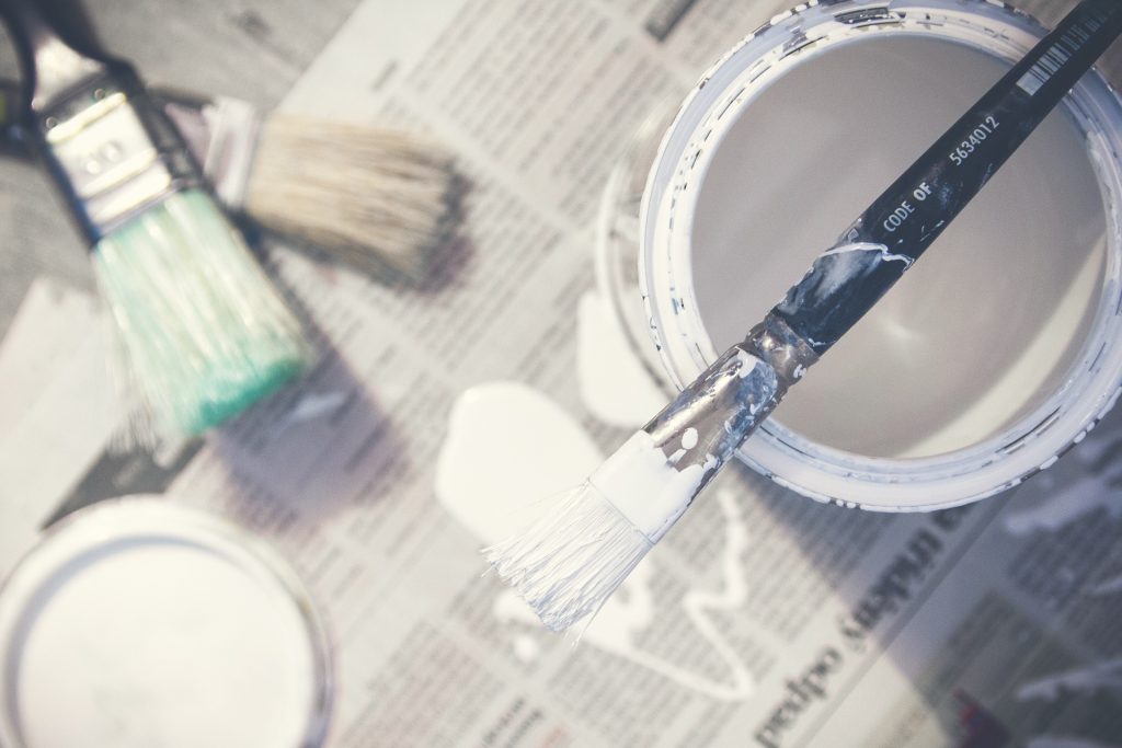 Paint cans and brushes on newspaper