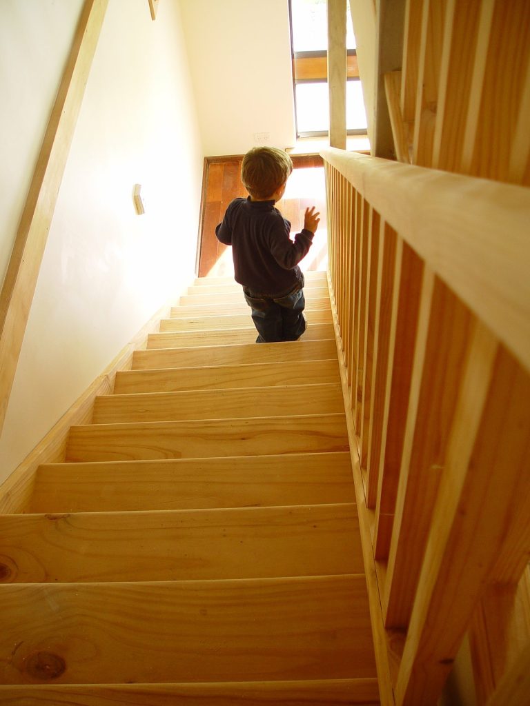 Toddler walking down wooden stairs