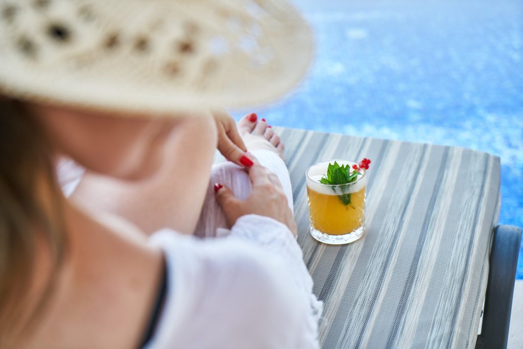 Woman sat on lounger with drink