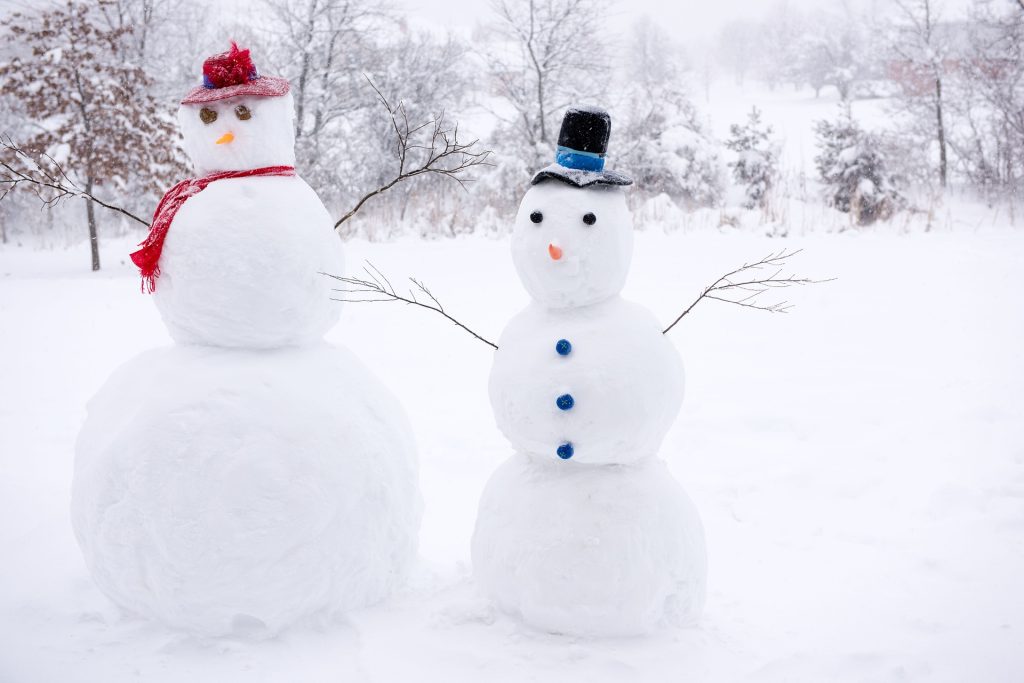 Two snowmen with hats on