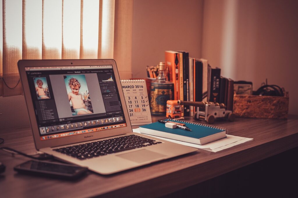 A laptop and notebook on a desk