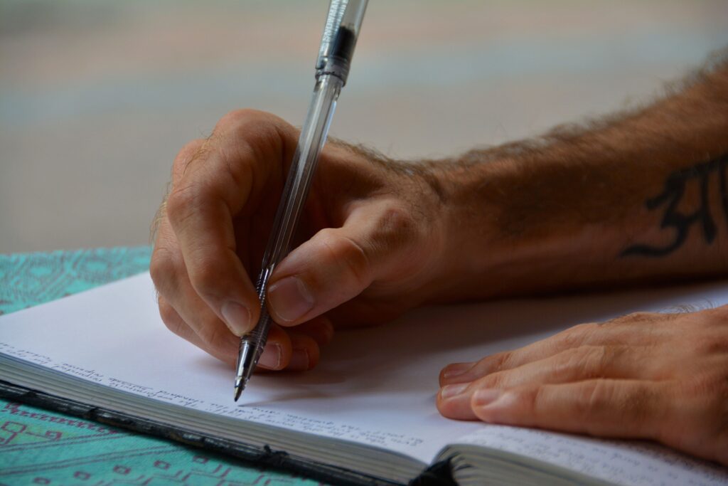 Hands holding a pen about to write on paper