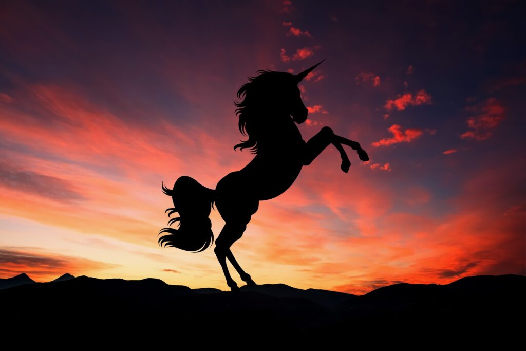 A silhouette of a unicorn in the sunset
