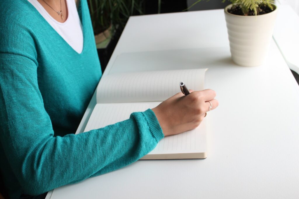 A hand holding a pen about to write on paper